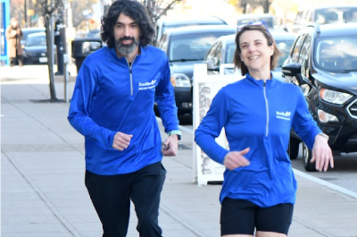 Chad Williams and Carly McCabe jogging on a sidwalk