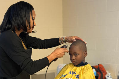 Woman giving a child a haircut
