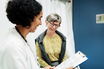 Doctor holding clipboard talking to patient