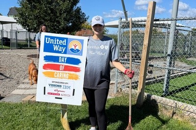 Volunteer standing next to United Way Day of Caring sign