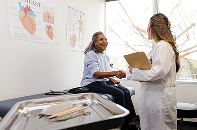 Doctor greets patient in exam room